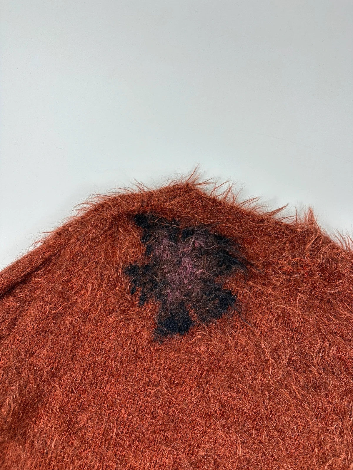 Acne Studios oversized cropped sweater in red and orange hairy knit texture.