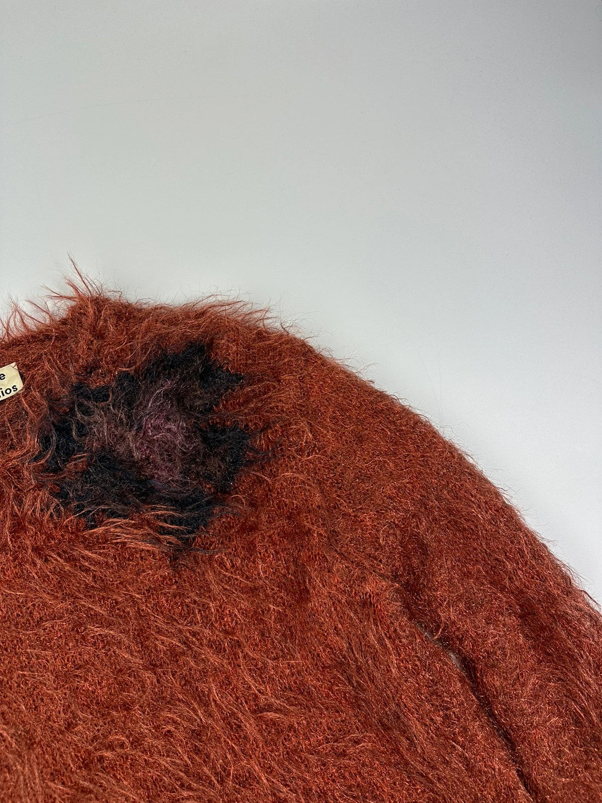 Acne Studios oversized cropped sweater in red and orange hairy knit texture.