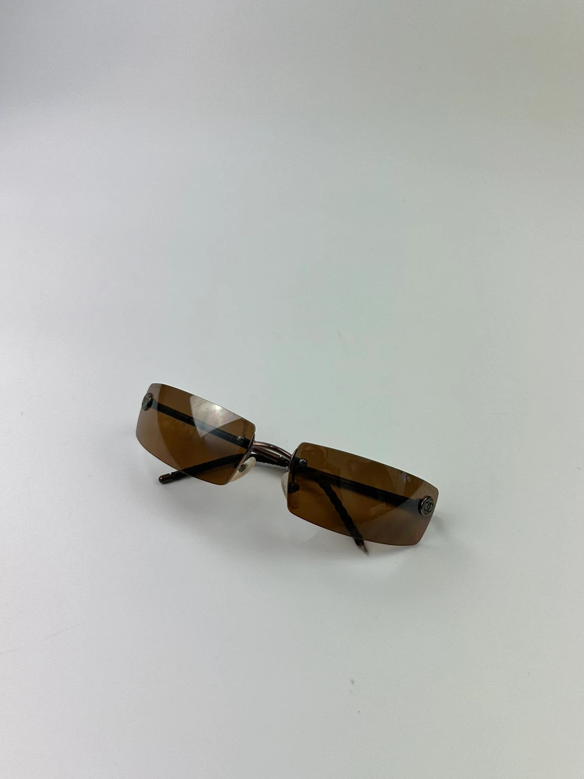 Chanel brown and orange rimless sunglasses with double CC logo detail.