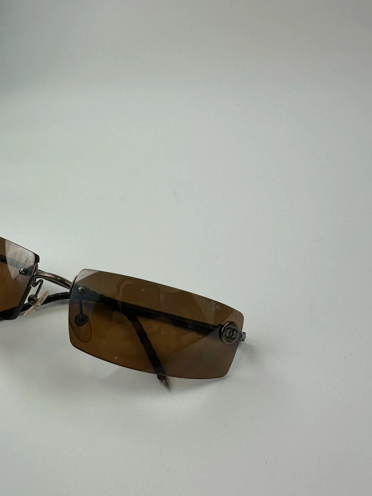 Chanel brown and orange rimless sunglasses with double CC logo detail.