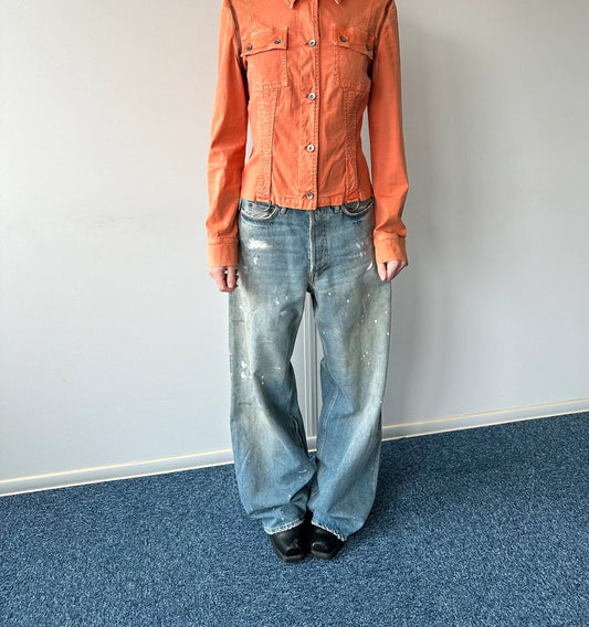 Acne Studios blue and white baggy jeans with intentional paint splatters and non-stretch denim.