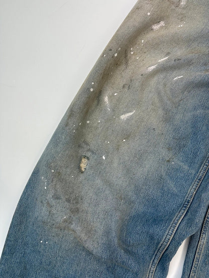 Acne Studios blue and white baggy jeans with intentional paint splatters and non-stretch denim.
