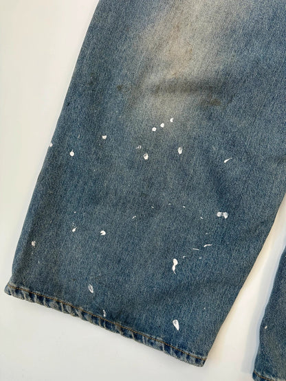 Acne Studios blue and white baggy jeans with intentional paint splatters and non-stretch denim.