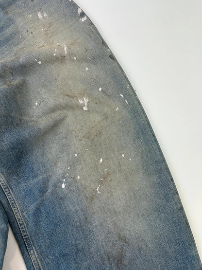 Acne Studios blue and white baggy jeans with intentional paint splatters and non-stretch denim.