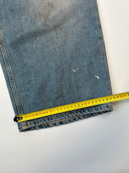Acne Studios blue and white baggy jeans with intentional paint splatters and non-stretch denim.