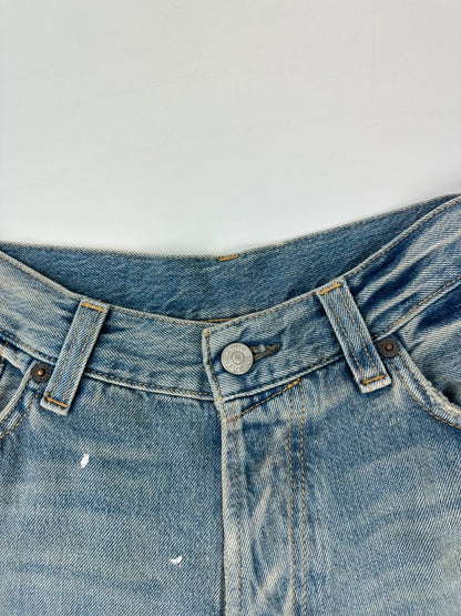 Acne Studios blue and white baggy jeans with intentional paint splatters and non-stretch denim.