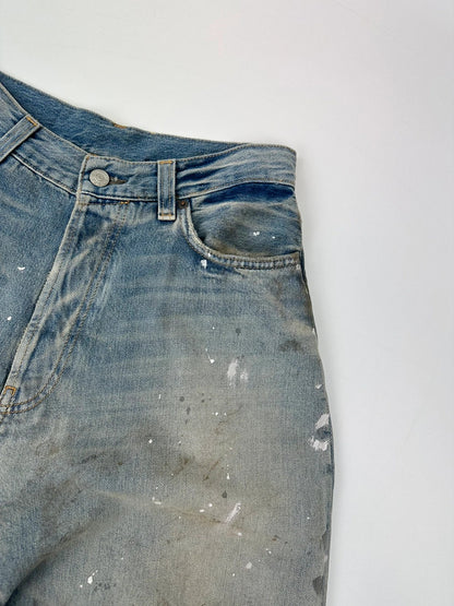 Acne Studios blue and white baggy jeans with intentional paint splatters and non-stretch denim.