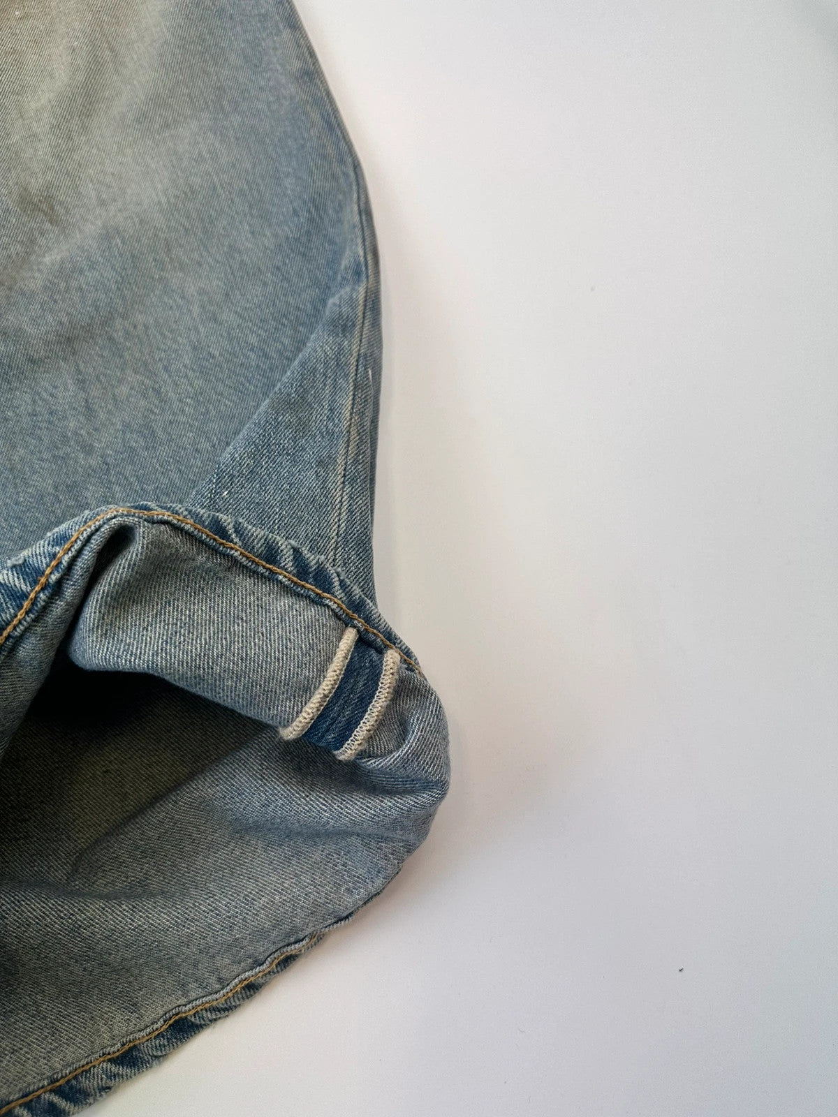 Acne Studios blue and white baggy jeans with intentional paint splatters and non-stretch denim.