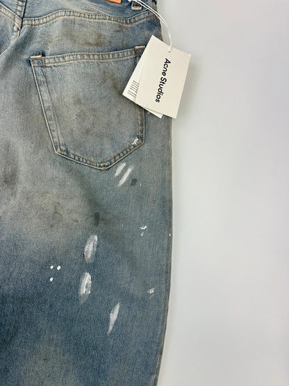 Acne Studios blue and white baggy jeans with intentional paint splatters and non-stretch denim.