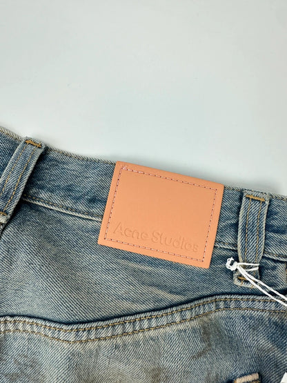 Acne Studios blue and white baggy jeans with intentional paint splatters and non-stretch denim.