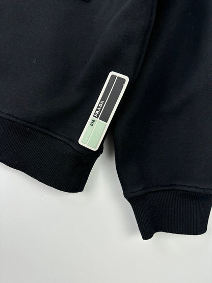 Prada black crop sweater with front pockets and logo detail, boxy fit.
