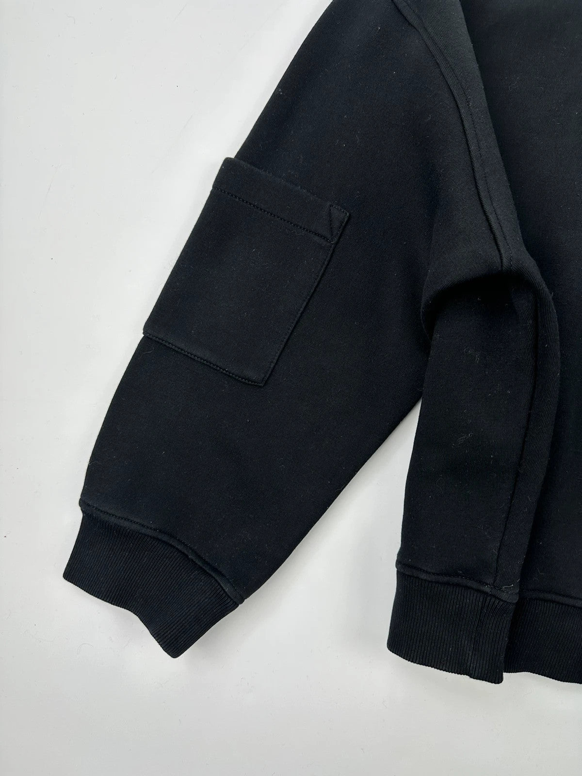 Prada black crop sweater with front pockets and logo detail, boxy fit.