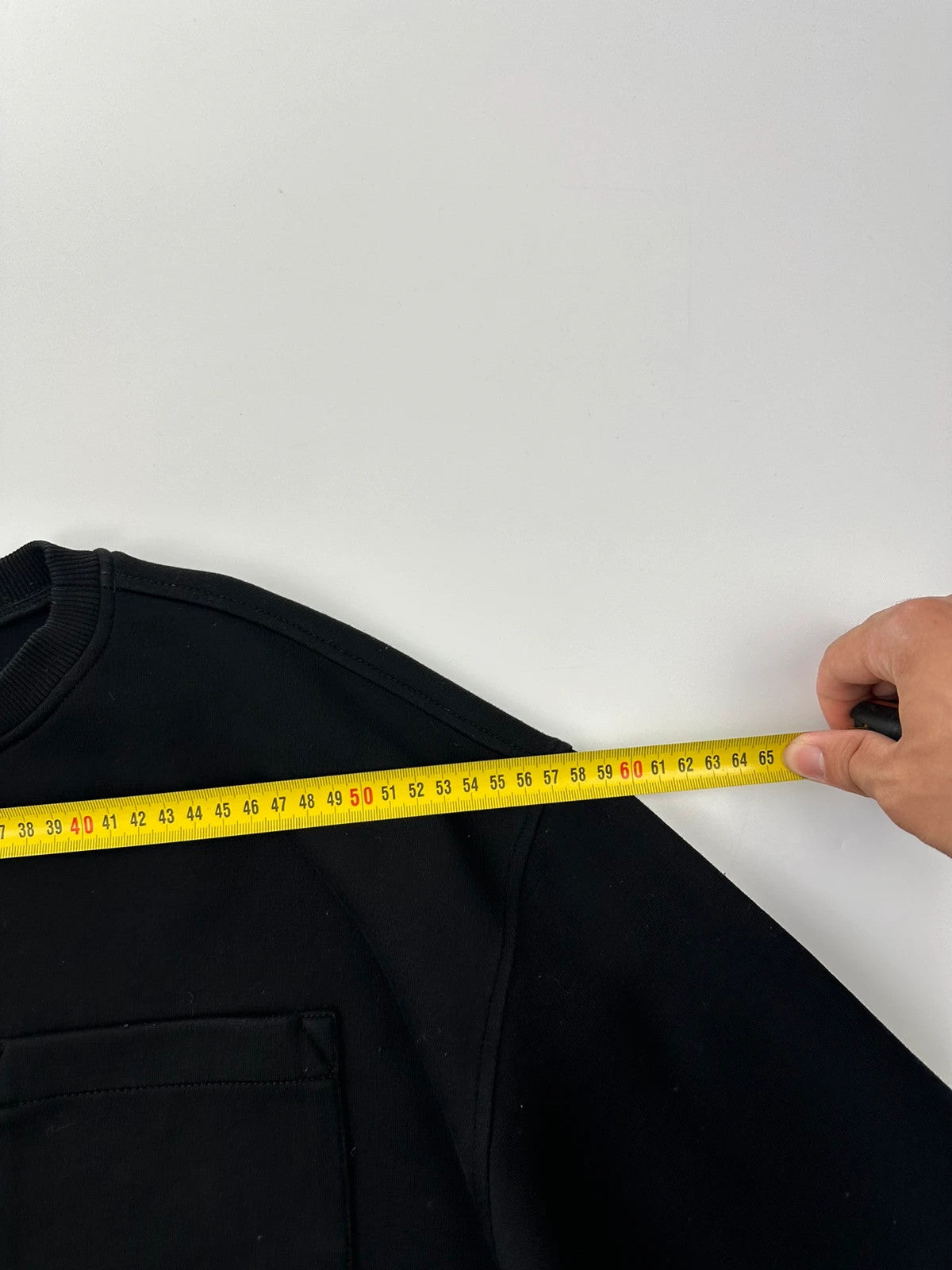 Prada black crop sweater with front pockets and logo detail, boxy fit.