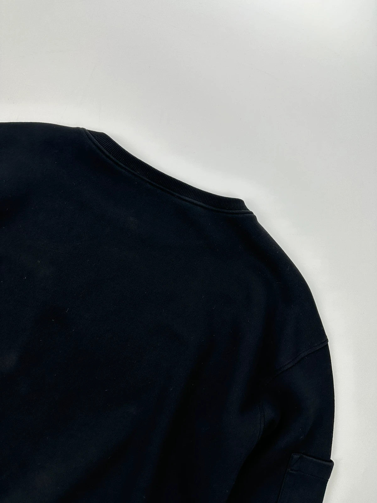Prada black crop sweater with front pockets and logo detail, boxy fit.