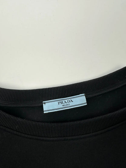 Prada black crop sweater with front pockets and logo detail, boxy fit.