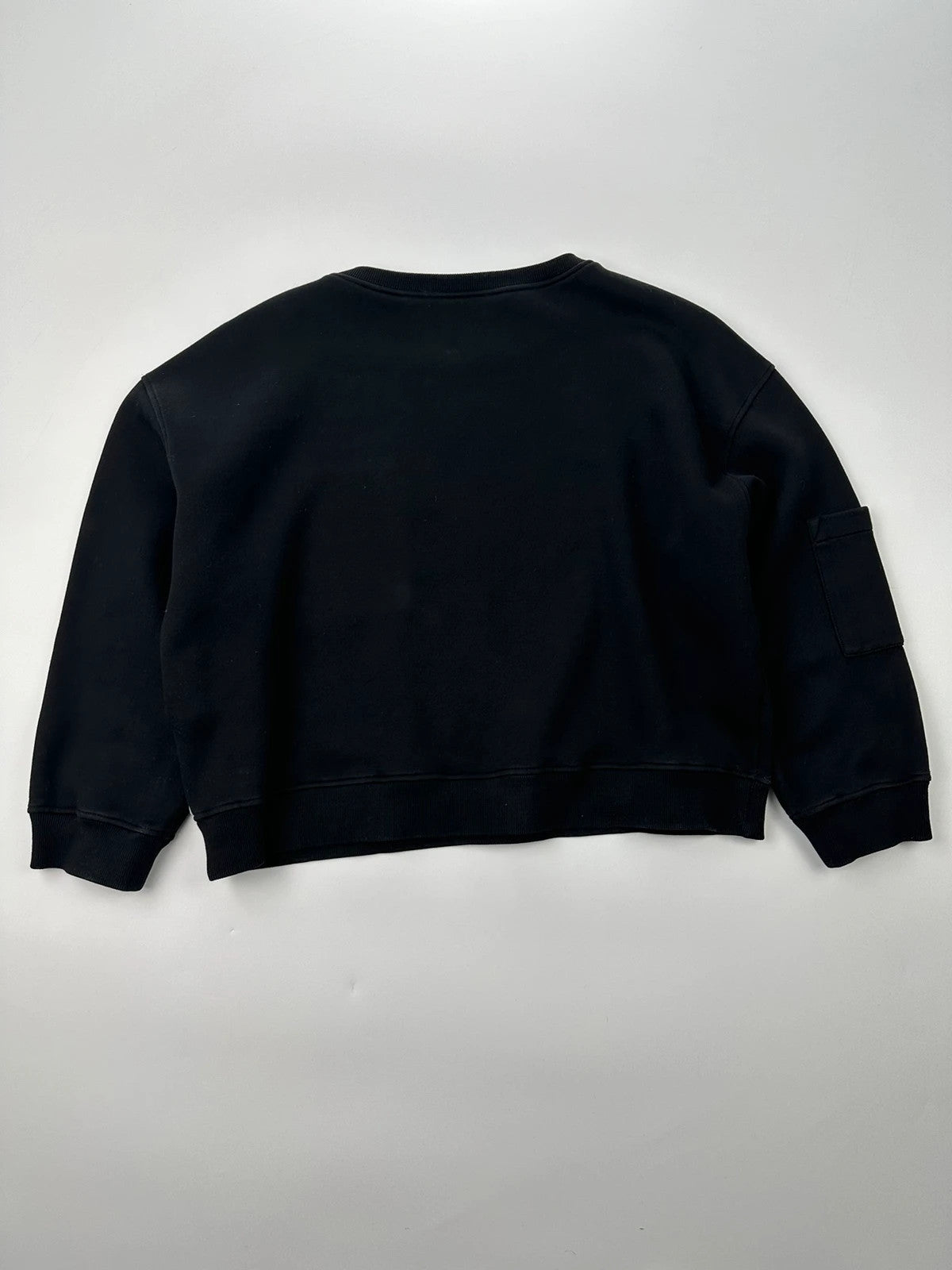 Prada black crop sweater with front pockets and logo detail, boxy fit.