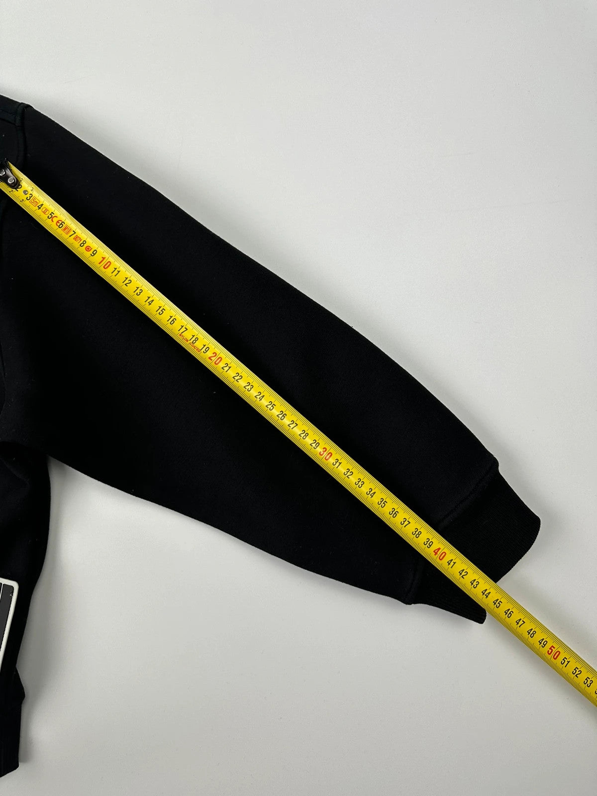 Prada black crop sweater with front pockets and logo detail, boxy fit.