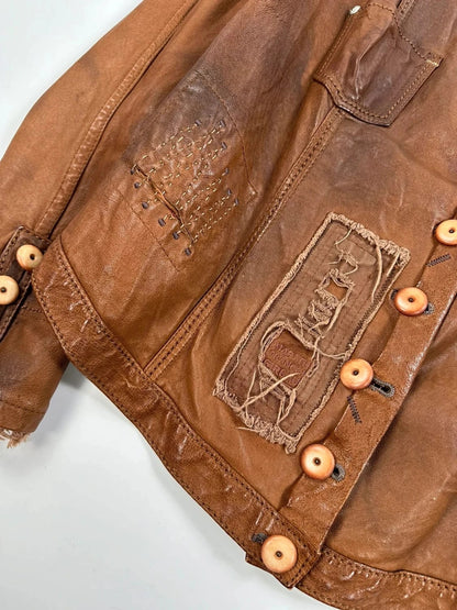 Marithé Francois Girbaud brown leather jacket with orange patches and logo details.