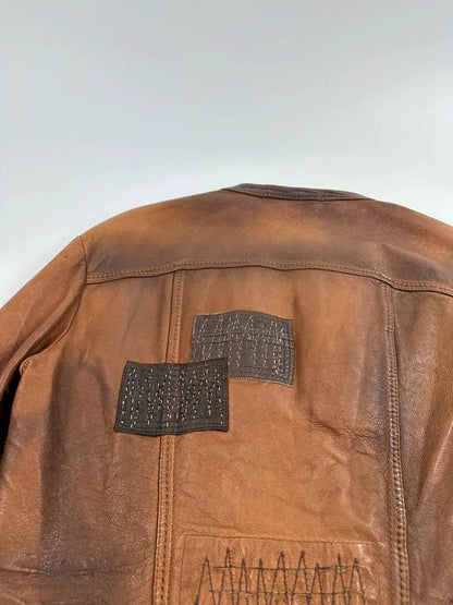 Marithé Francois Girbaud brown leather jacket with orange patches and logo details.