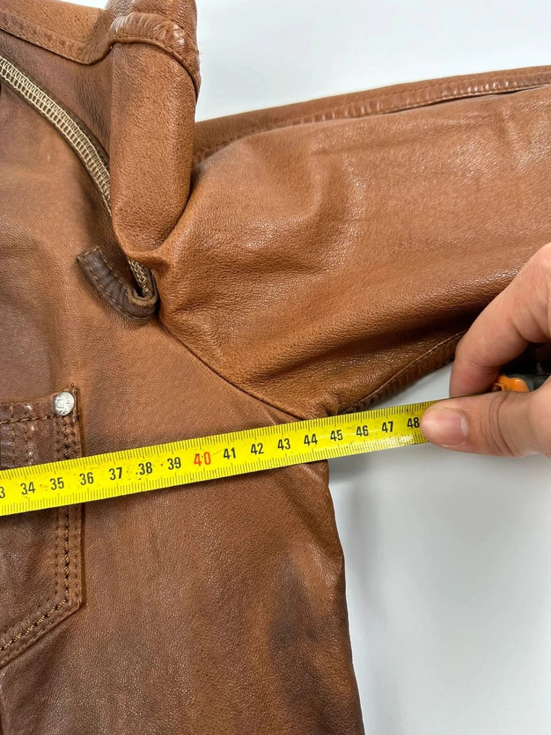 Marithé Francois Girbaud brown leather jacket with orange patches and logo details.