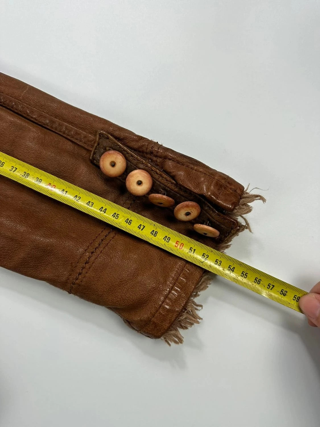 Marithé Francois Girbaud brown leather jacket with orange patches and logo details.