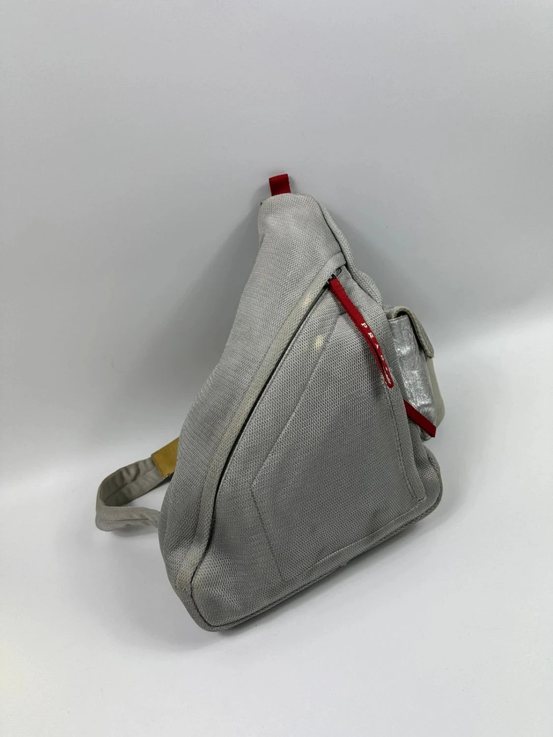 Prada grey sling bag with silver mesh and patent leather, featuring a collector's design.