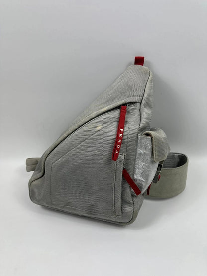 Prada grey sling bag with silver mesh and patent leather, featuring a collector's design.