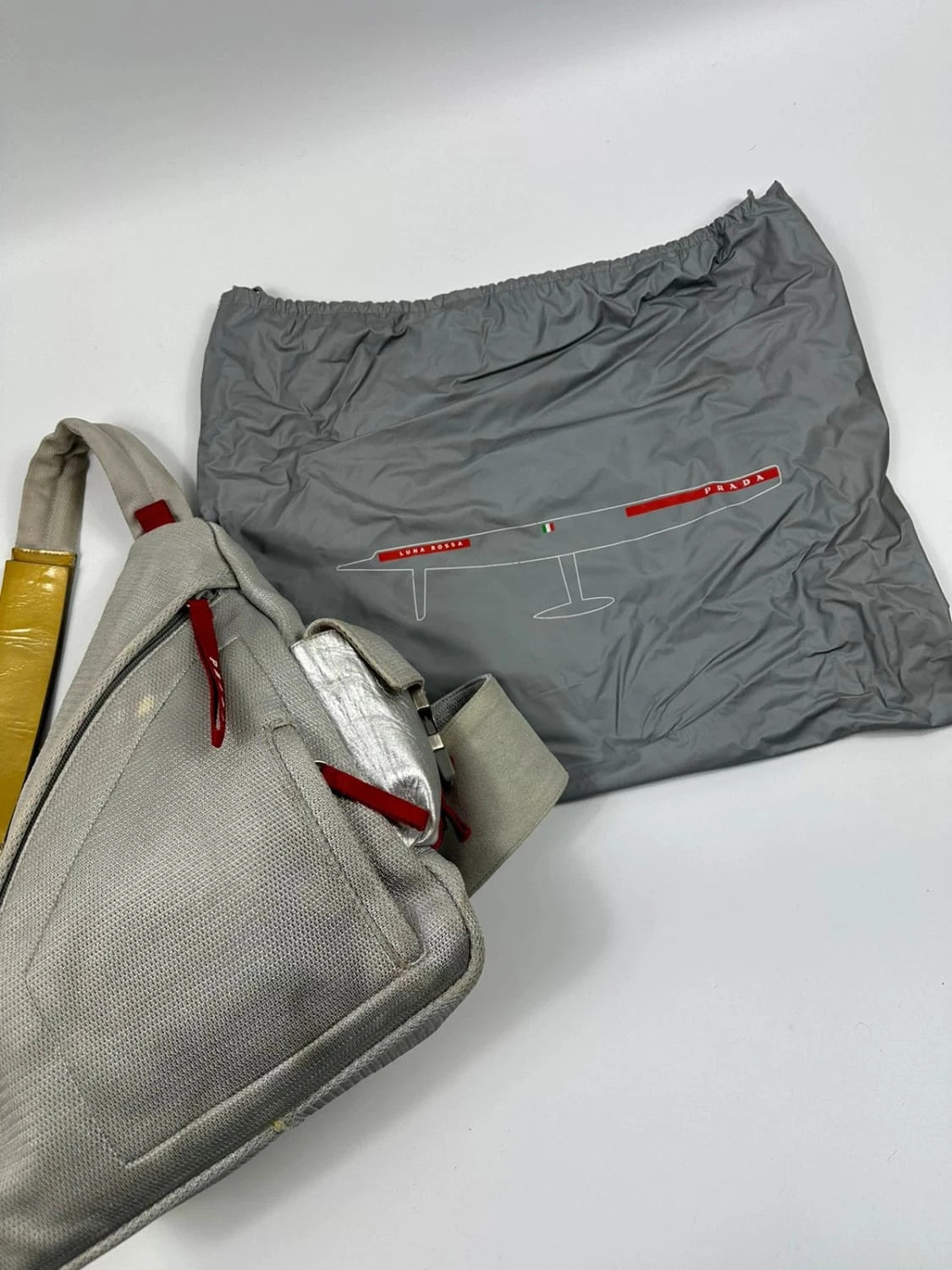 Prada grey sling bag with silver mesh and patent leather, featuring a collector's design.
