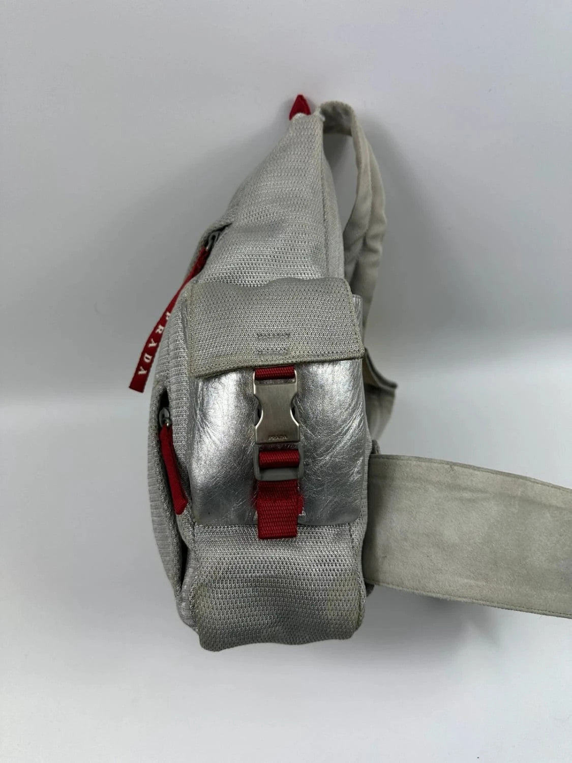 Prada grey sling bag with silver mesh and patent leather, featuring a collector's design.