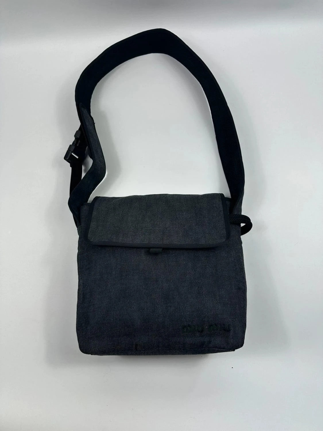 Miu Miu 90s denim crossbody sling bag in black and grey with logo detail.