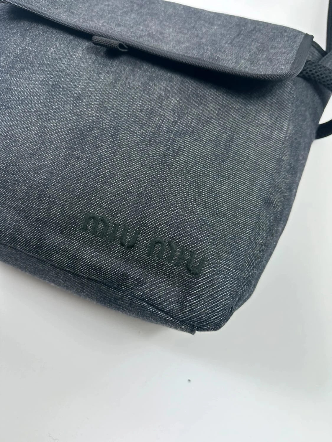 Miu Miu 90s denim crossbody sling bag in black and grey with logo detail.
