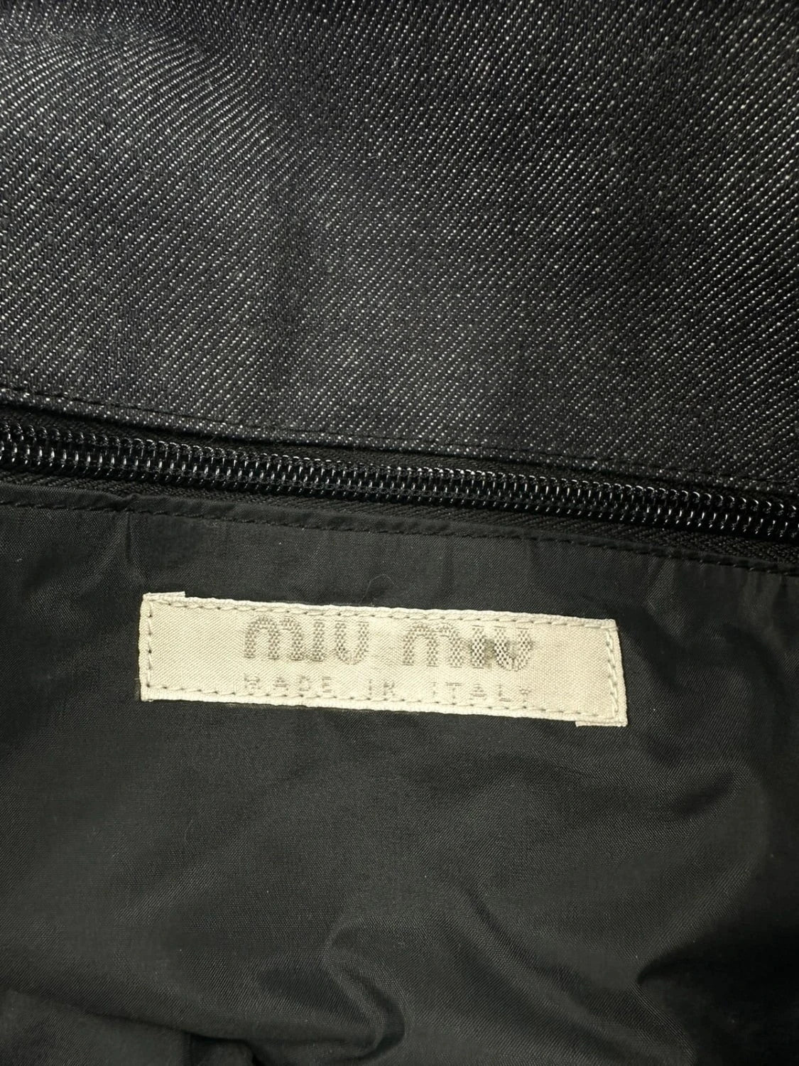 Miu Miu 90s denim crossbody sling bag in black and grey with logo detail.