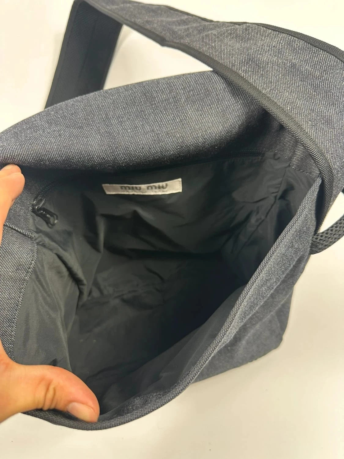 Miu Miu 90s denim crossbody sling bag in black and grey with logo detail.