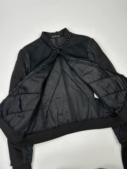 Marithé Francois Girbaud black coat with white utility stitching and logo details.