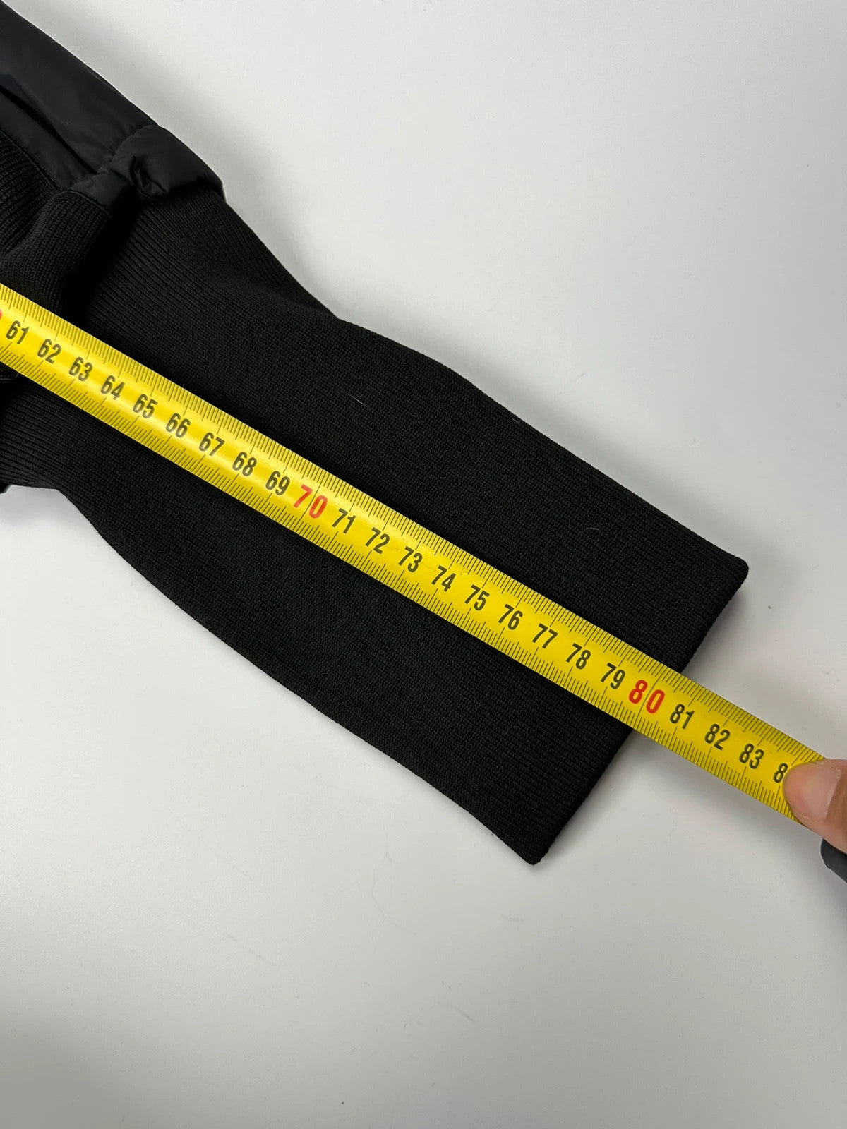 Marithé Francois Girbaud black coat with white utility stitching and logo details.