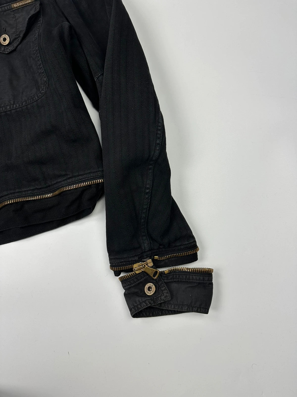 Dolce & Gabbana black denim jacket with detachable features and logo detailing.