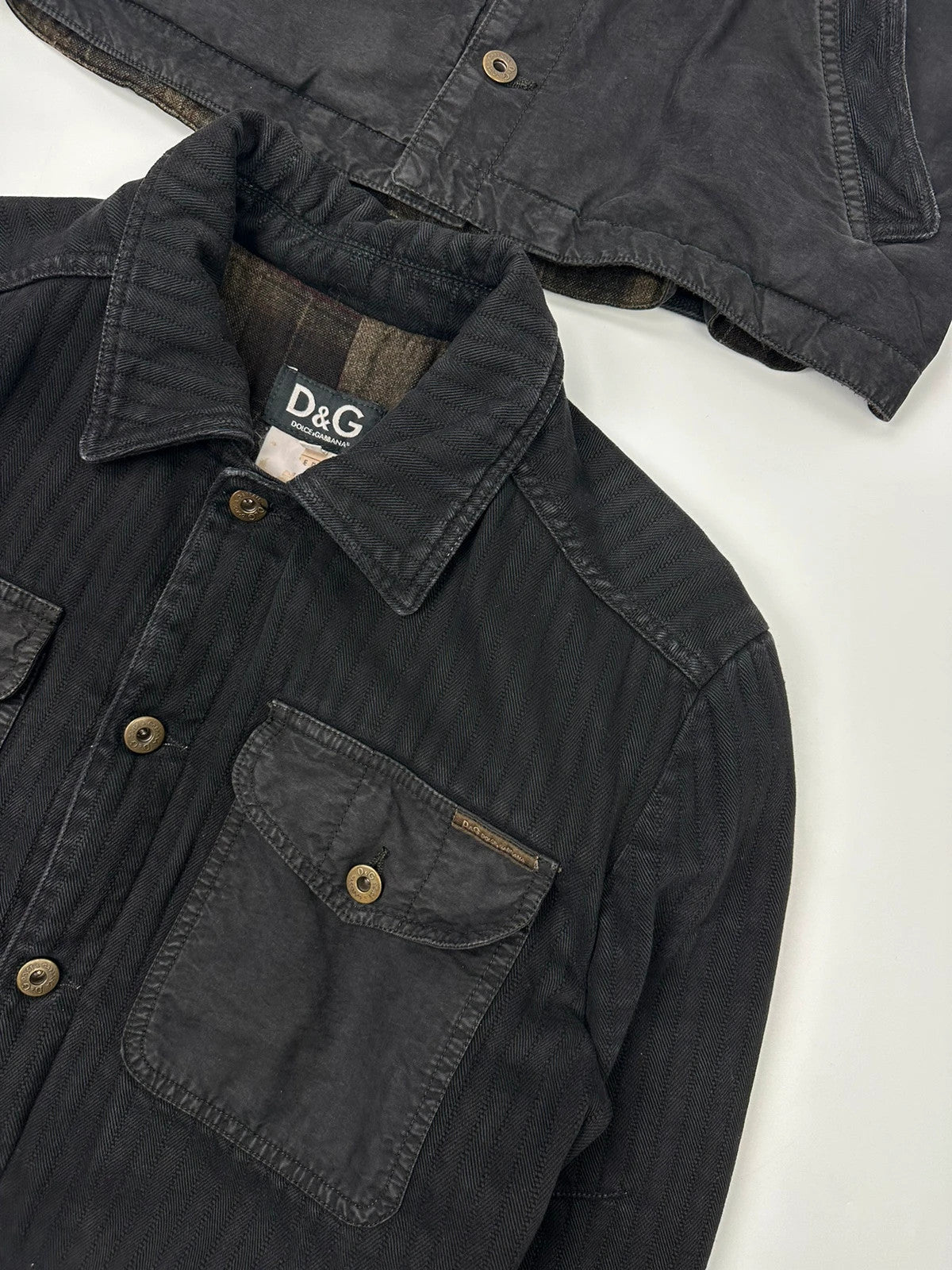 Dolce & Gabbana black denim jacket with detachable features and logo detailing.