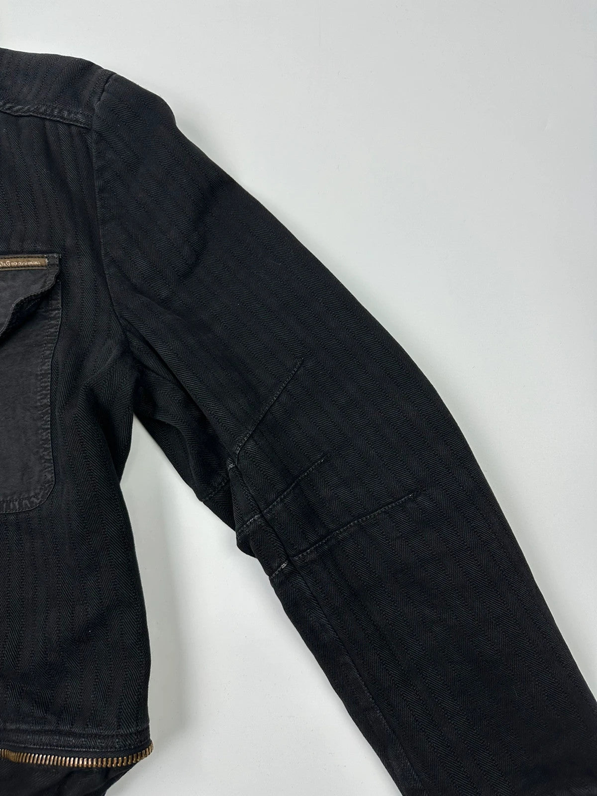 Dolce & Gabbana black denim jacket with detachable features and logo detailing.
