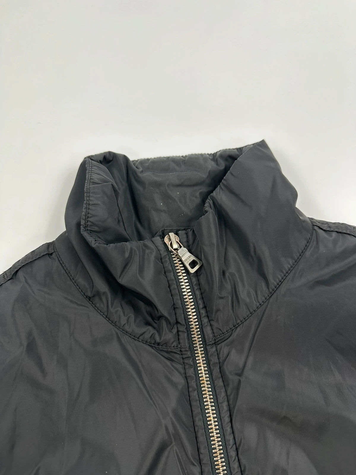 Prada black padded nylon jacket with double zip and minimalist design.