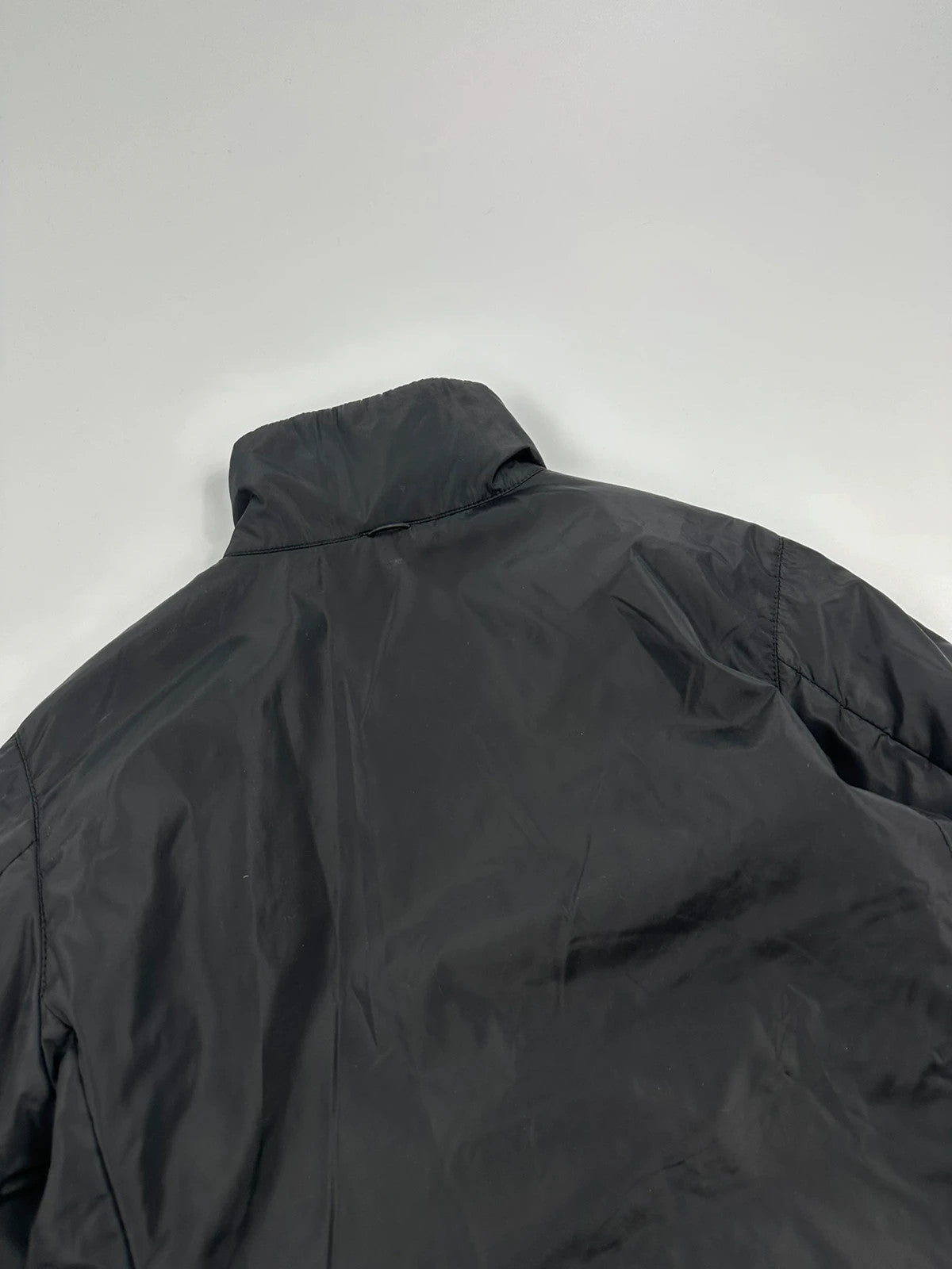 Prada black padded nylon jacket with double zip and minimalist design.