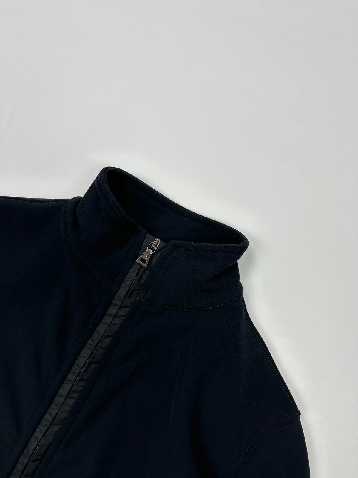 Prada black zip-up jacket featuring fleece material and iconic logo detail.