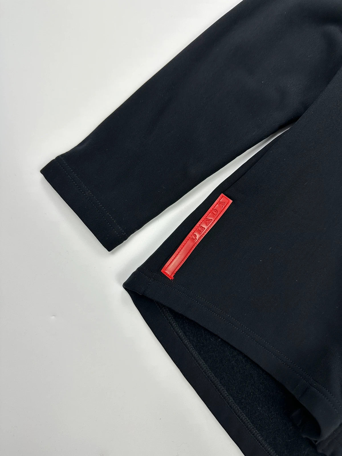 Prada black zip-up jacket featuring fleece material and iconic logo detail.