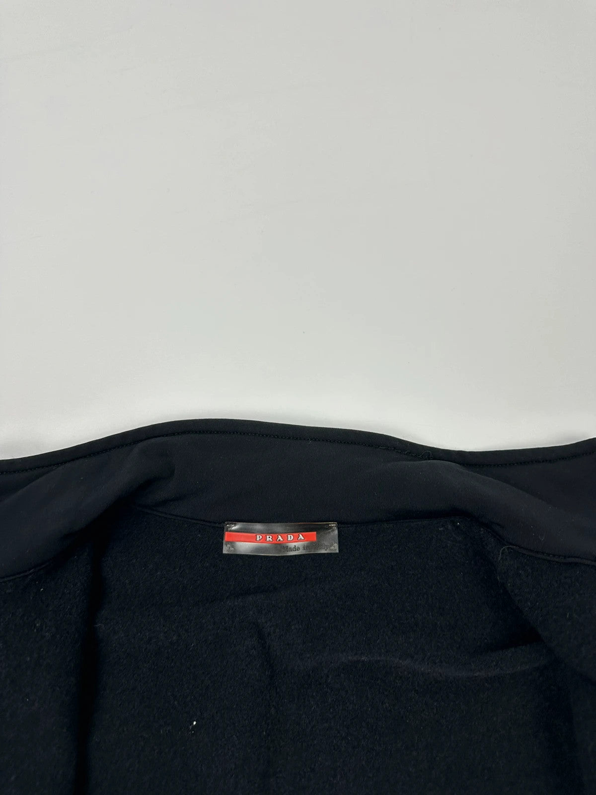 Prada black zip-up jacket featuring fleece material and iconic logo detail.