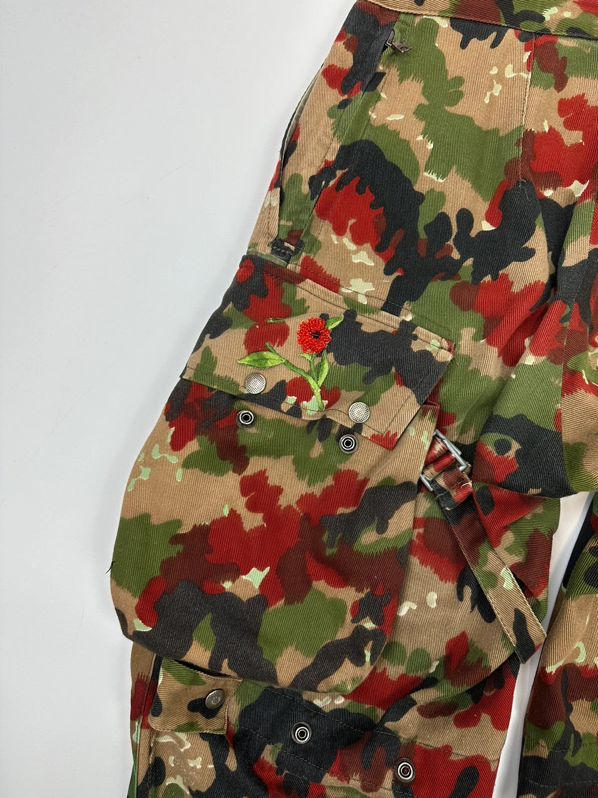 Dolce & Gabbana green camo wide-leg trousers with reworked straps and military pattern.