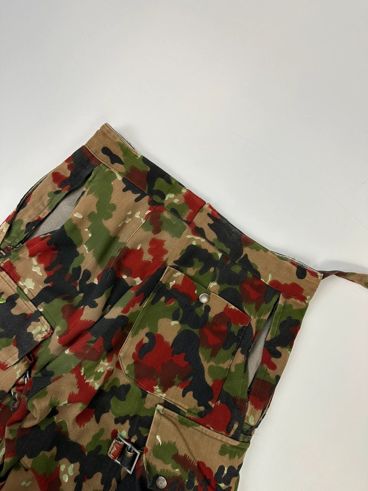 Dolce & Gabbana green camo wide-leg trousers with reworked straps and military pattern.