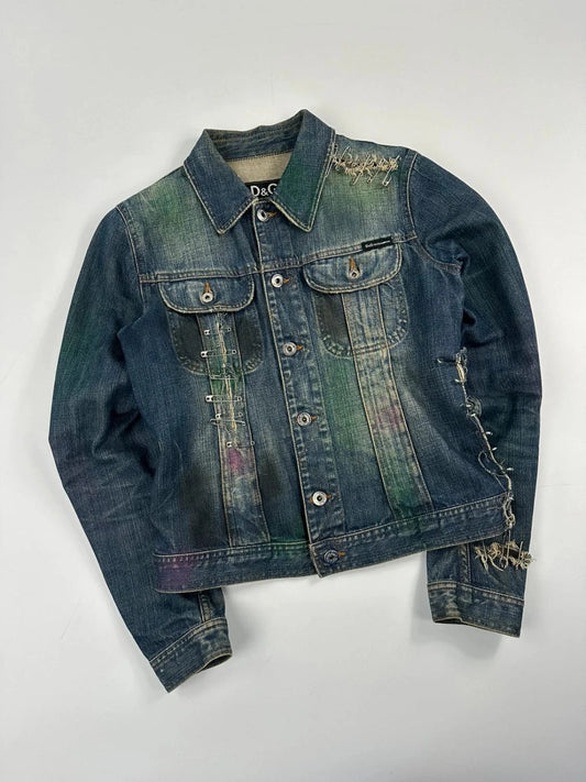 Dolce & Gabbana blue distressed denim jacket with painted details and pins.