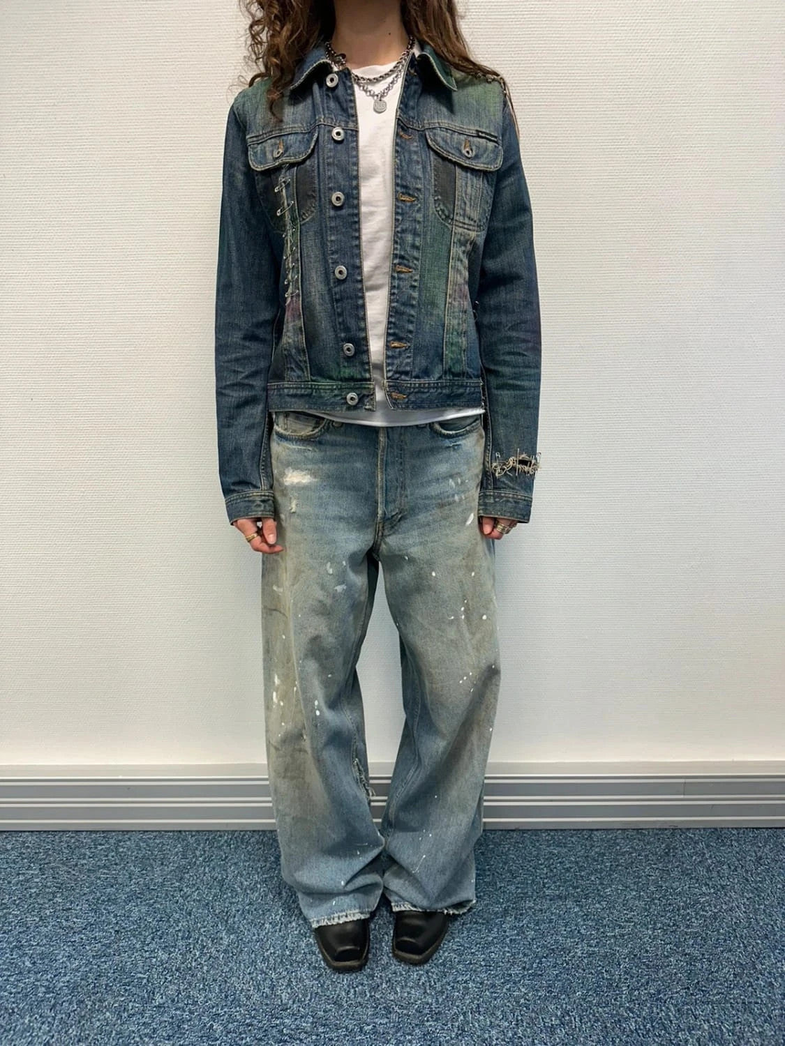 Dolce & Gabbana blue distressed denim jacket with painted details and pins.