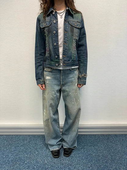 Dolce & Gabbana blue distressed denim jacket with painted details and pins.