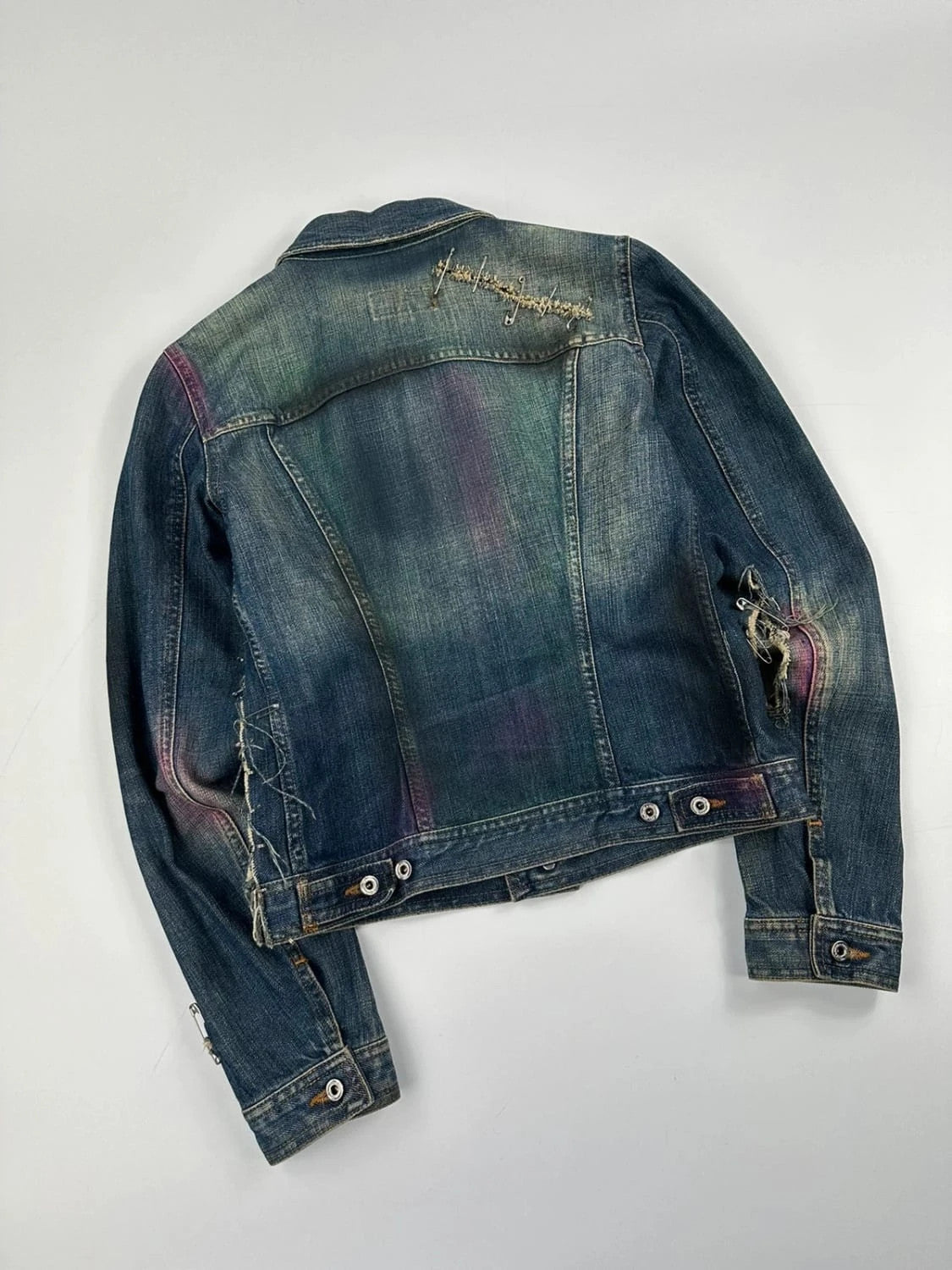 Dolce & Gabbana blue distressed denim jacket with painted details and pins.
