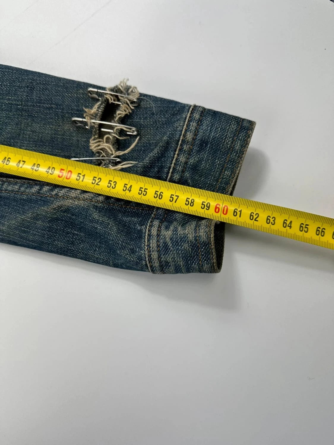 Dolce & Gabbana blue distressed denim jacket with painted details and pins.